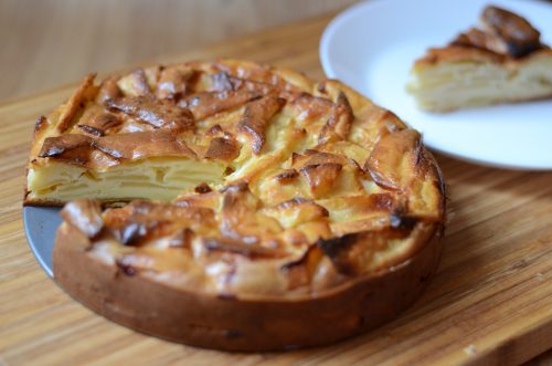 This image shows a soft pudding for babies made with apples, baked in a round shape and set on a wooden board.